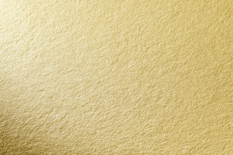 Close-up of a matte gold textured surface filling the frame