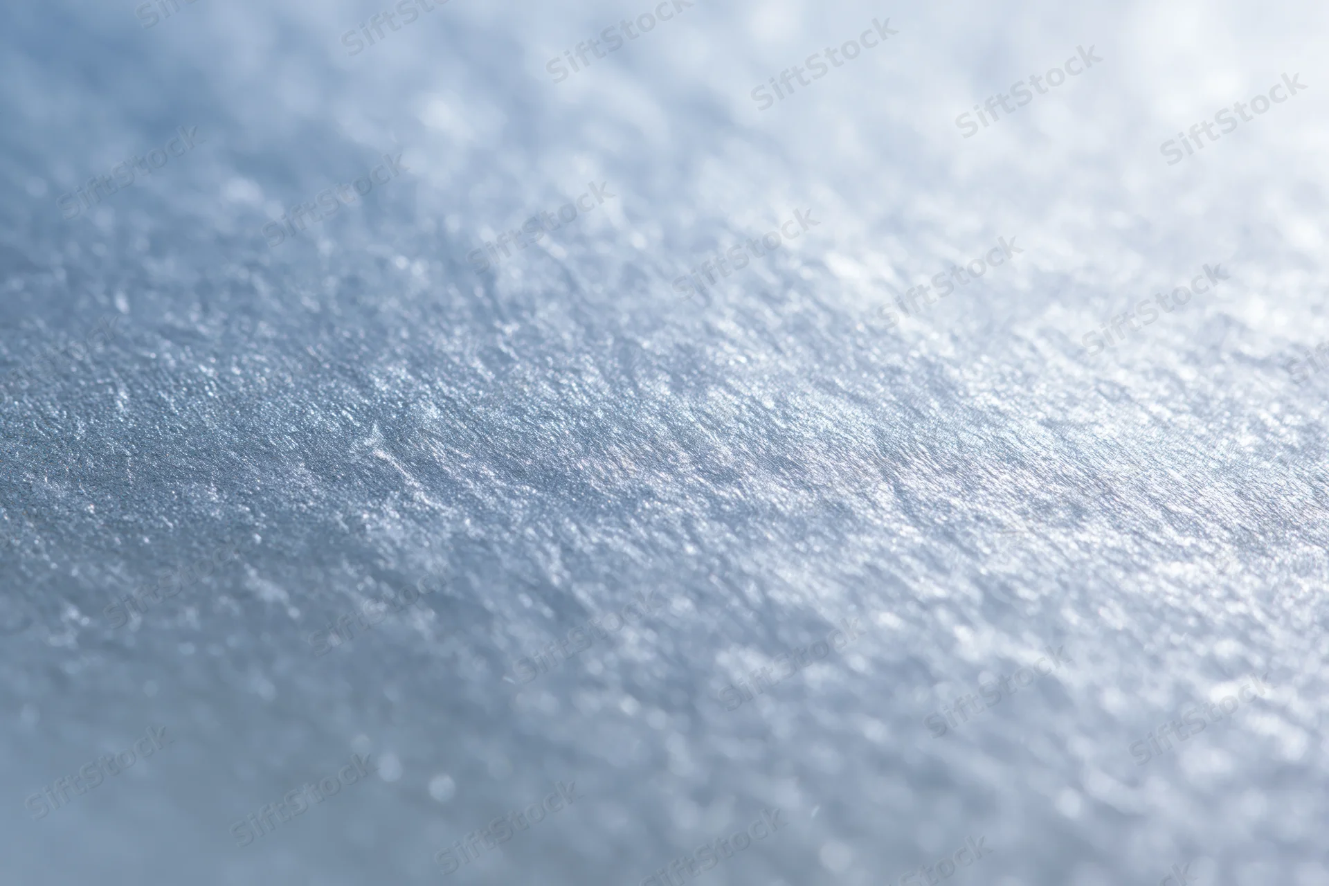 Close-up of frosted glass or brushed metallic foil surface with shimmering texture