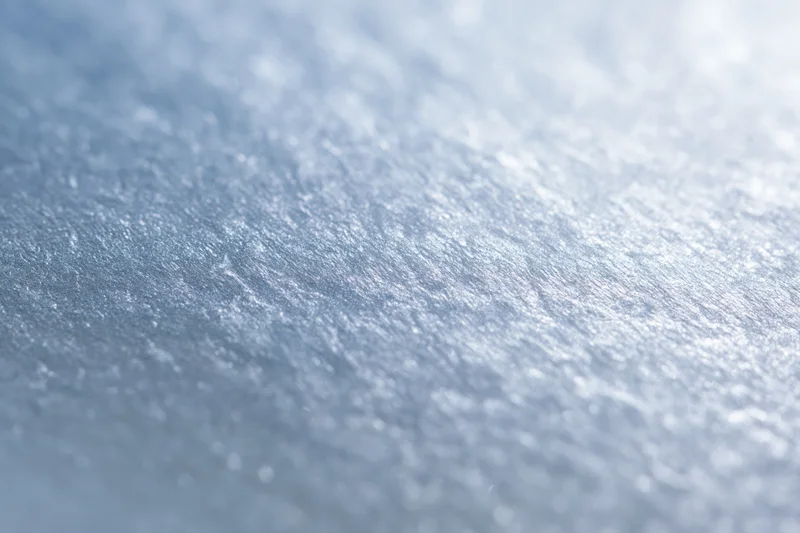 Close-up of frosted glass or brushed metallic foil surface with shimmering texture