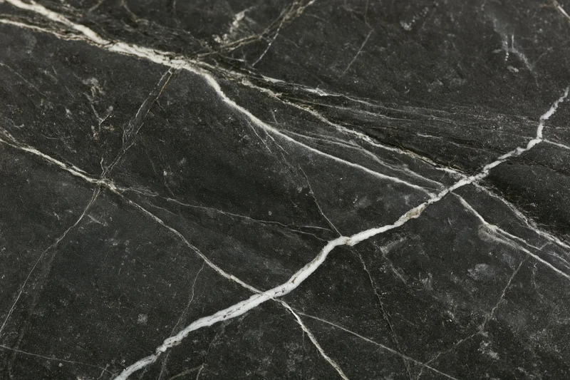Close-up of polished black marble surface with white veining filling the frame