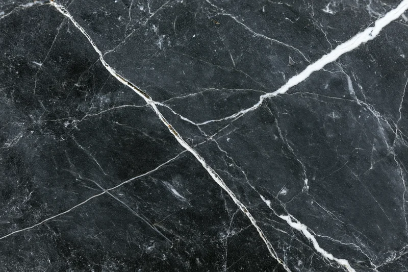 Close-up of polished black marble surface with white veining filling the frame