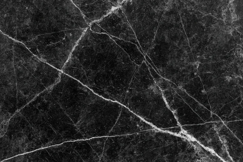 Close-up of polished black marble surface with white veining filling the frame