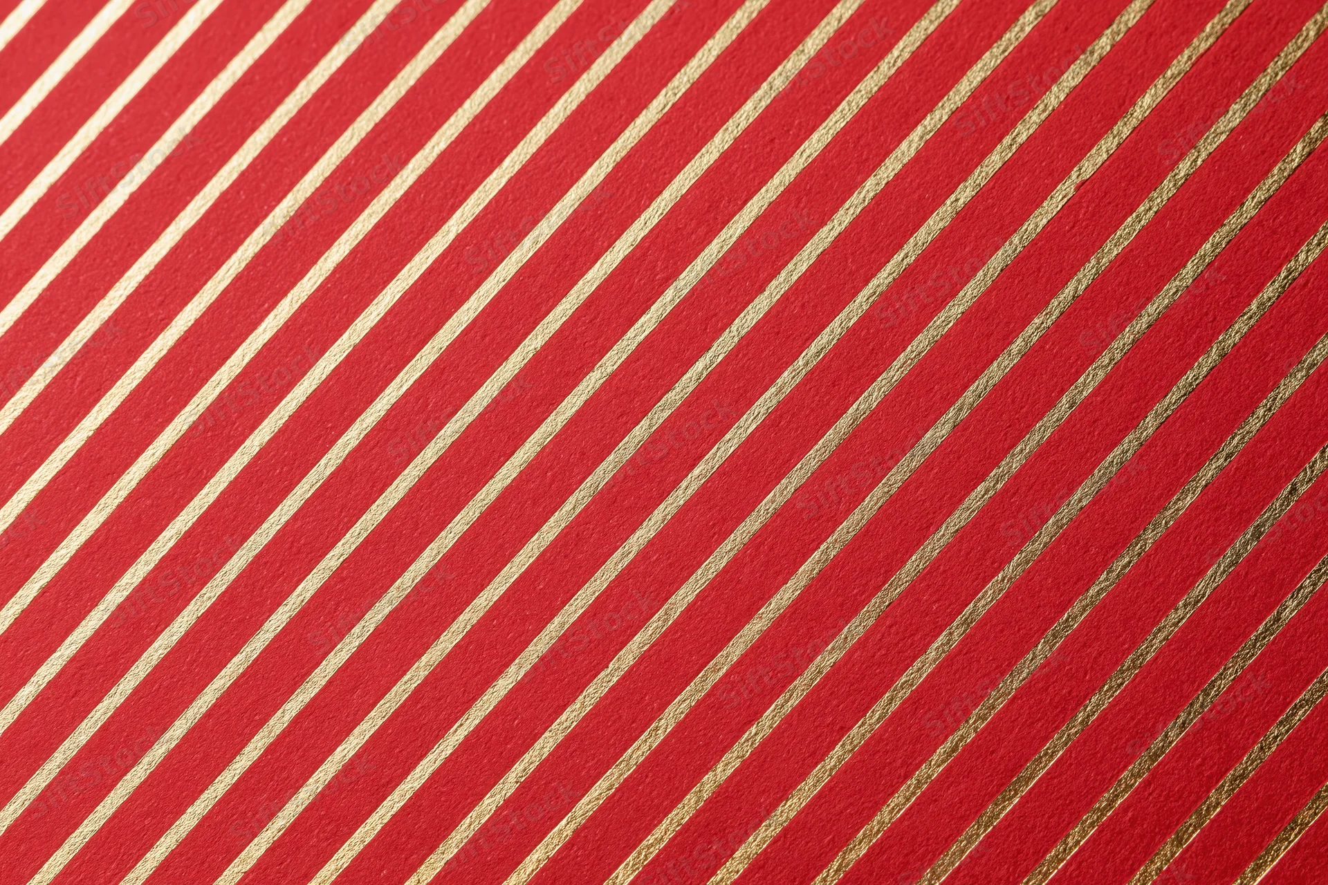 Red wrapping paper with diagonal gold stripes for gift decoration