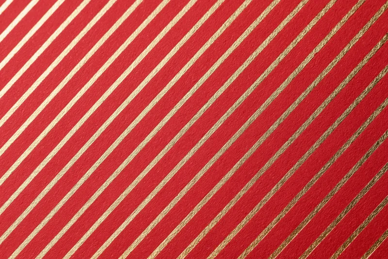 Red wrapping paper with diagonal gold stripes for gift decoration