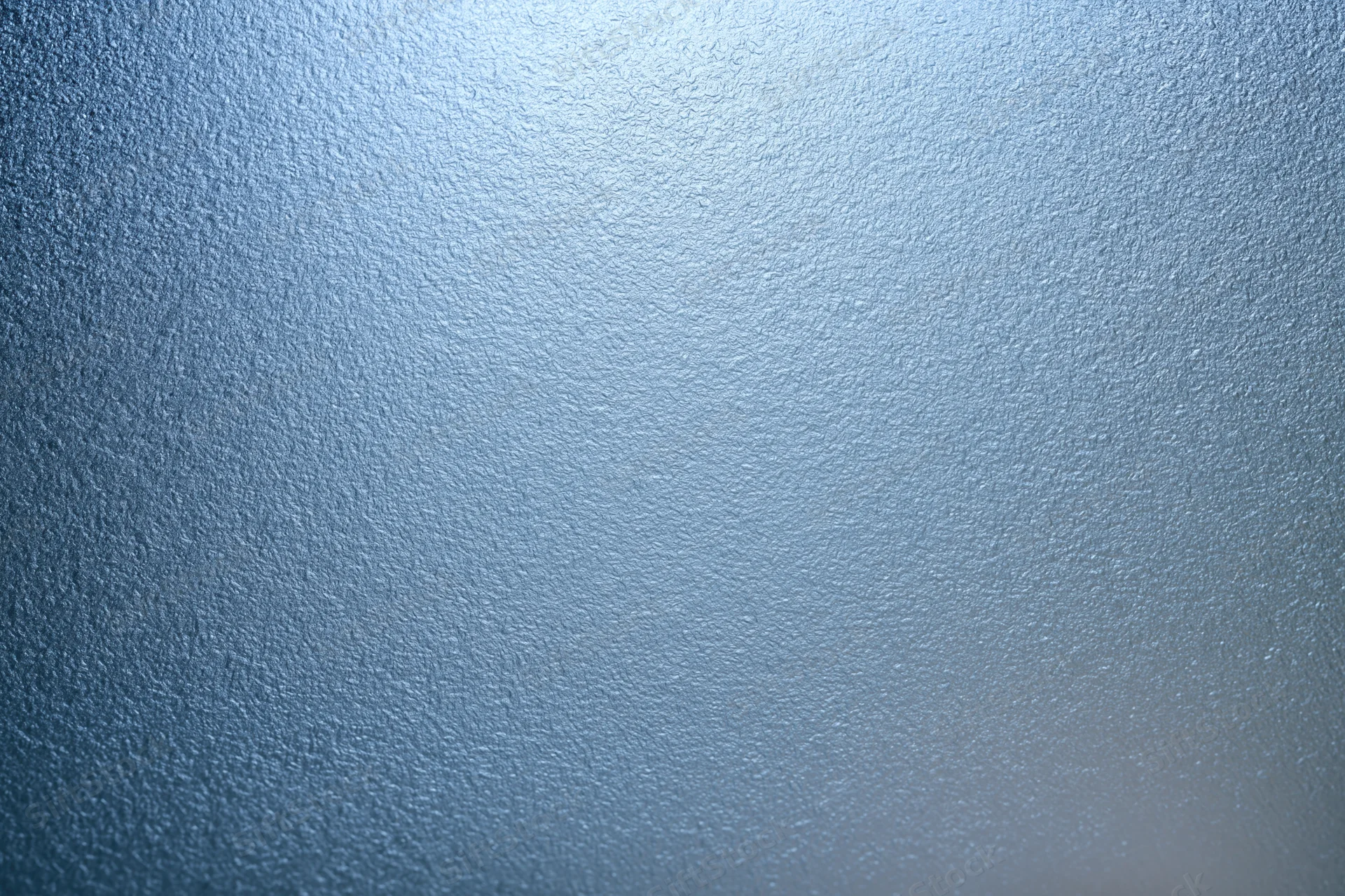 Close-up of frosted glass surface with fine uniform texture and blue gradient lighting
