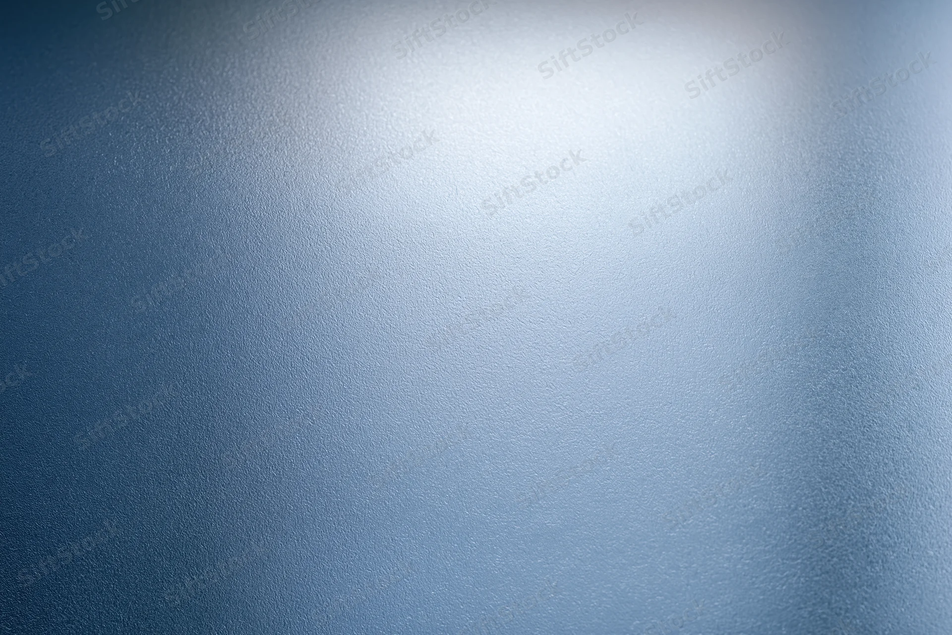 Close-up of frosted glass surface with smooth texture and blue gradient lighting