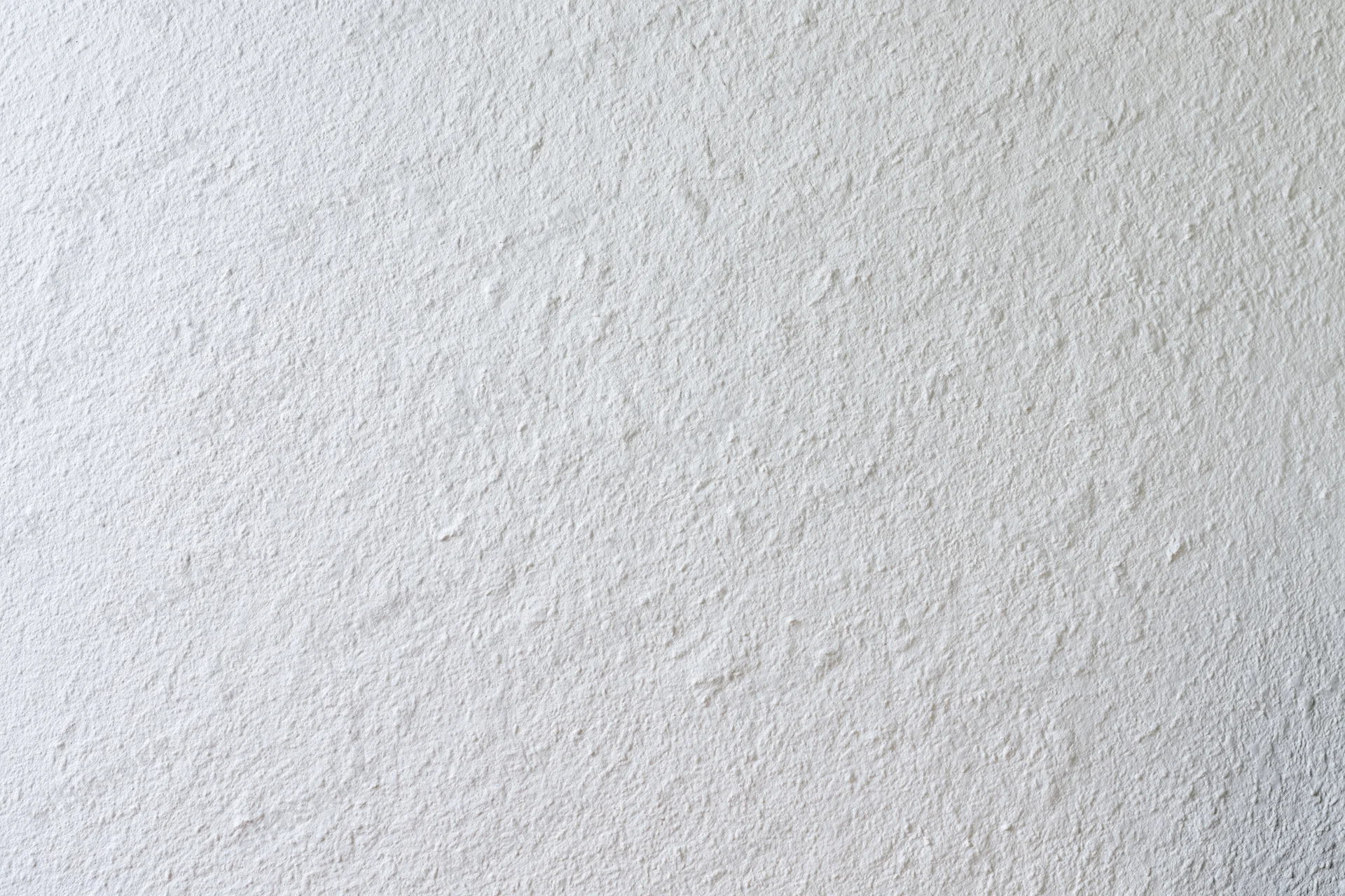 Close-up of a plain white painted wall surface with textured finish