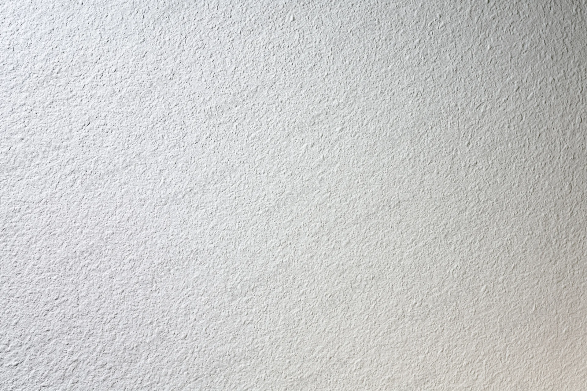 Close-up of a plain white painted wall surface with textured finish