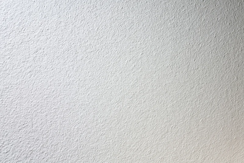 Close-up of a plain white painted wall surface with textured finish