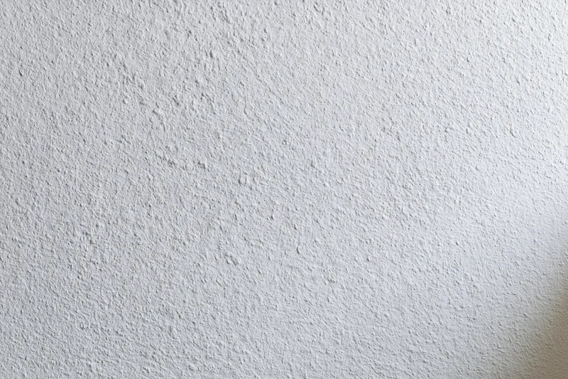 Close-up of a plain white painted wall surface with textured finish