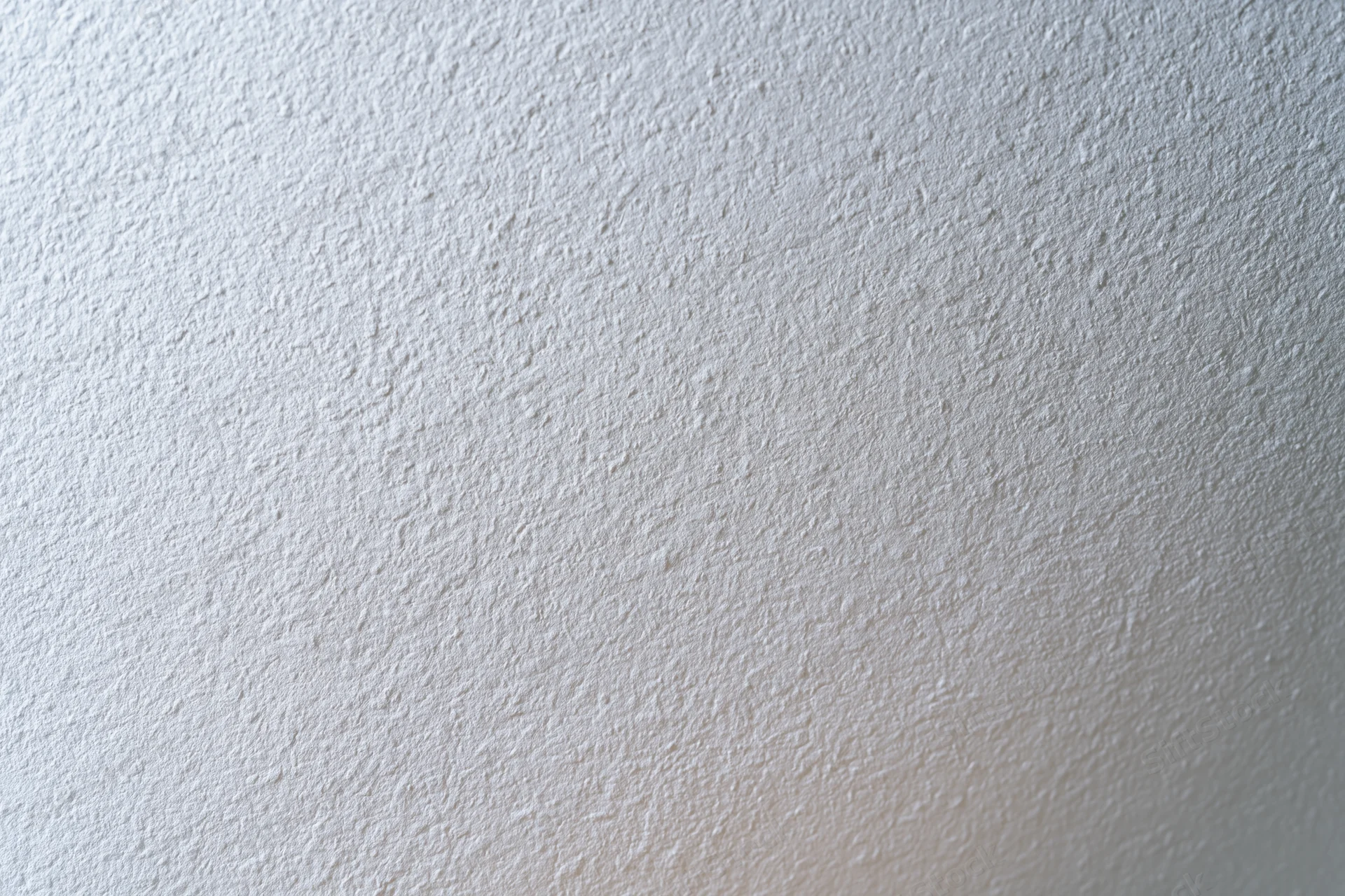 Close-up of a plain white painted wall surface with textured finish