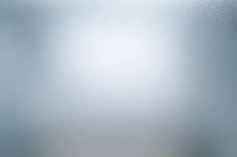 Close-up of frosted glass surface with soft light gradient and diffuse texture