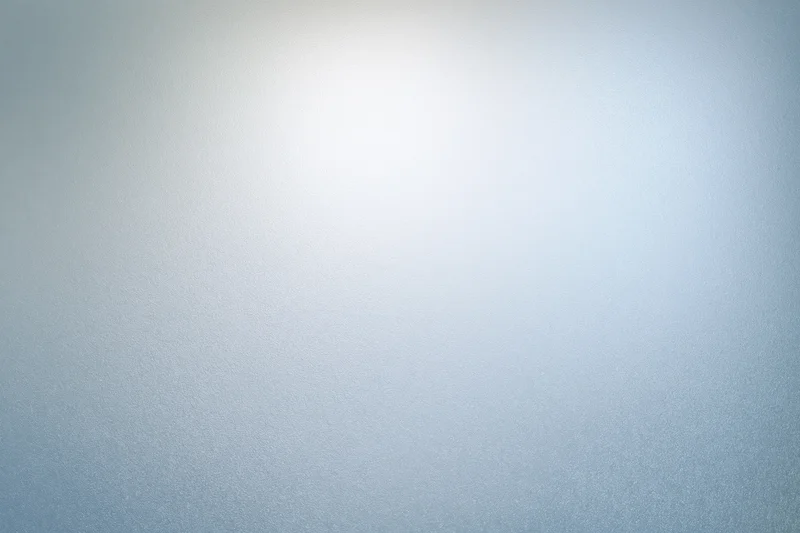 Frosted glass surface with soft light gradient and subtle texture filling the frame