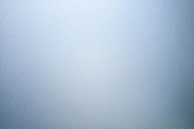 Frosted glass surface with subtle texture and light gradient filling the frame