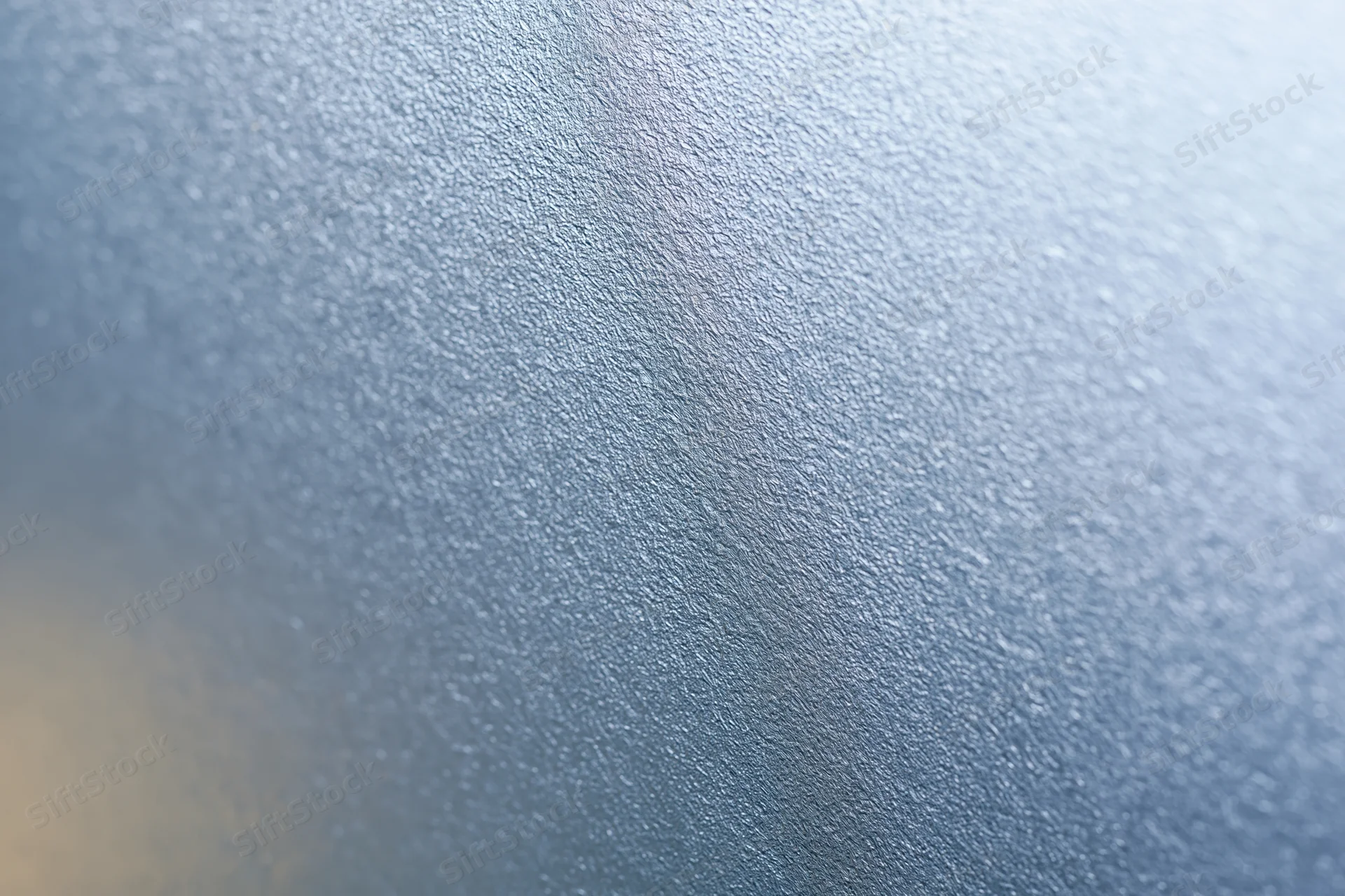 Close-up of frosted glass surface with textured pattern and soft light gradient