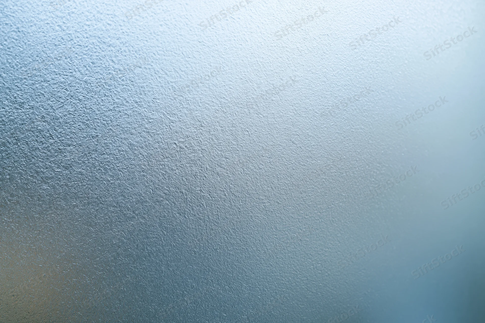 Close-up of frosted glass surface with blue gradient and textured pattern filling the frame