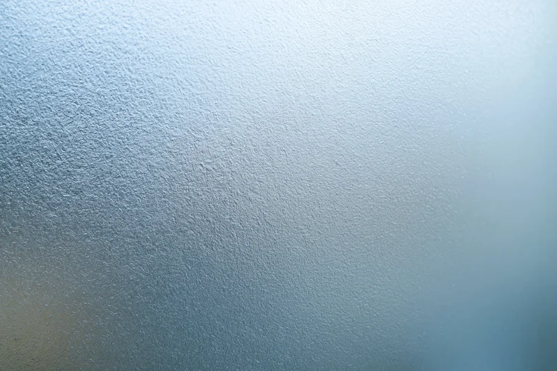 Close-up of frosted glass surface with blue gradient and textured pattern filling the frame