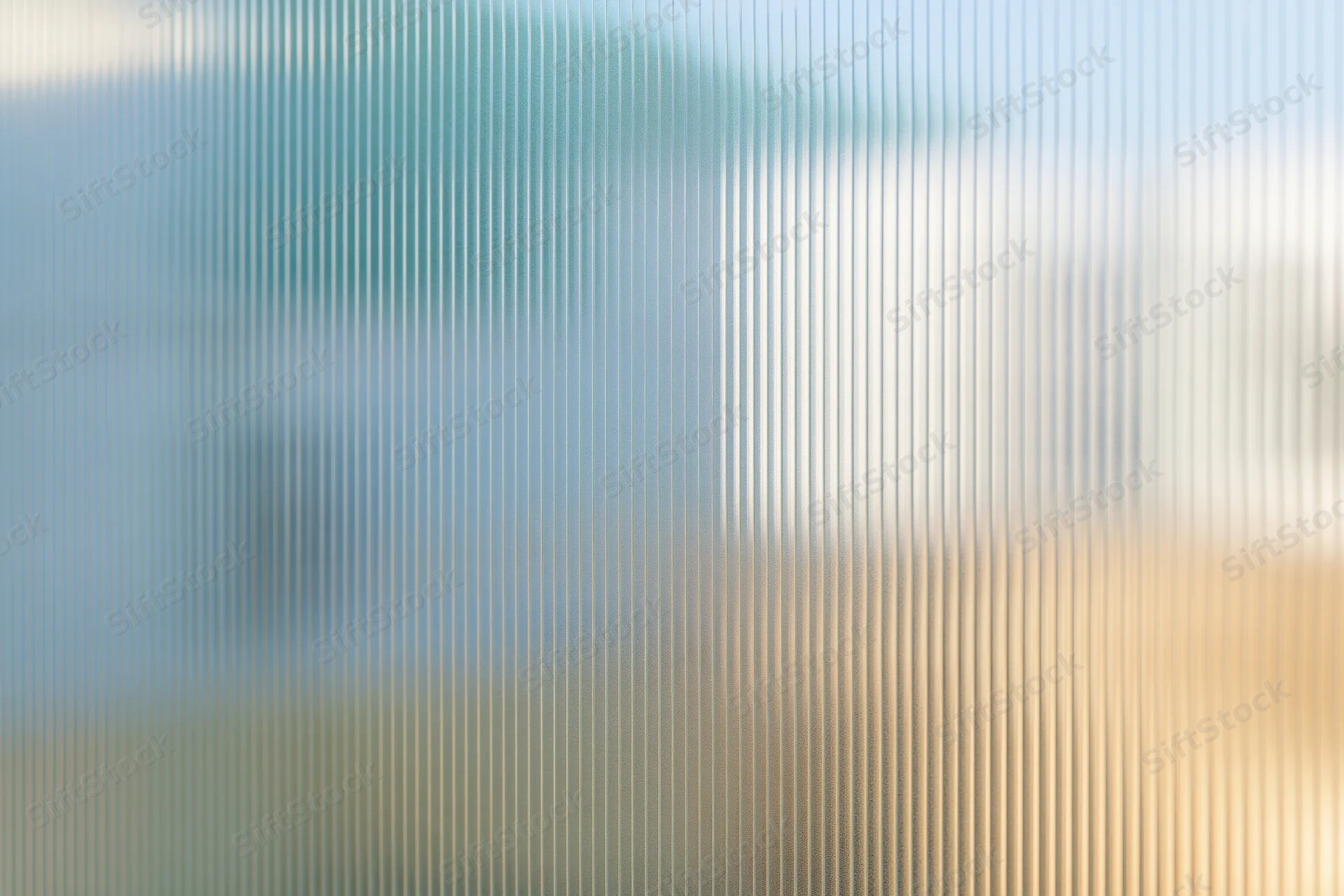 Close-up of ribbed translucent glass panel with vertical lines and diffused light, showing texture and pattern as a modern interior surface
