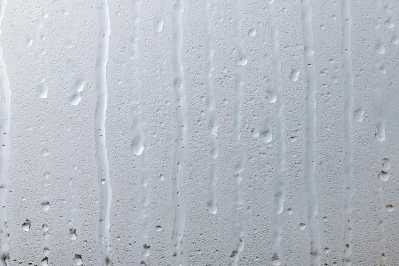 Close-up of water droplets and streaks on a wet glass surface