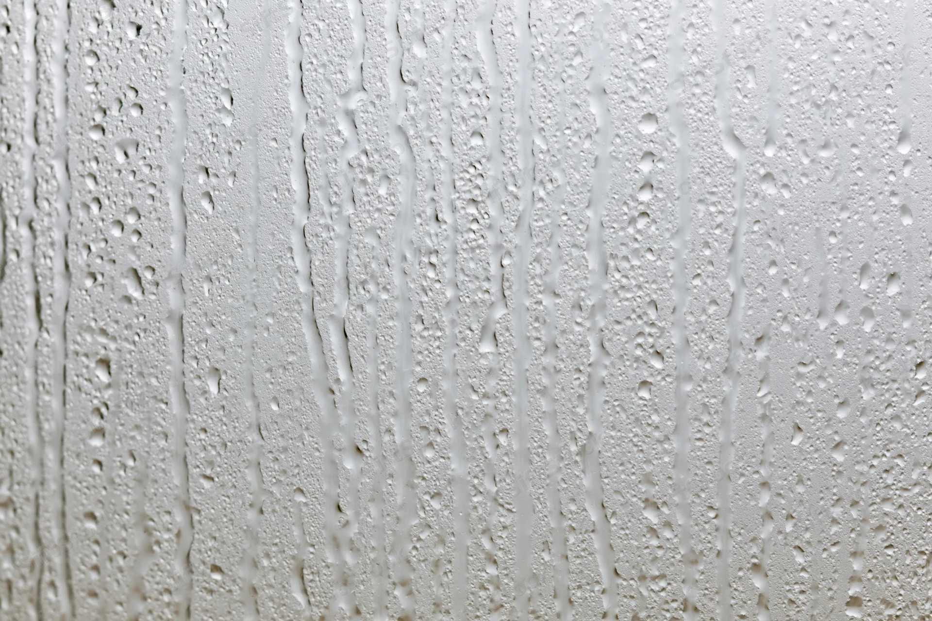 Close-up of water droplets and streaks on a wet glass surface