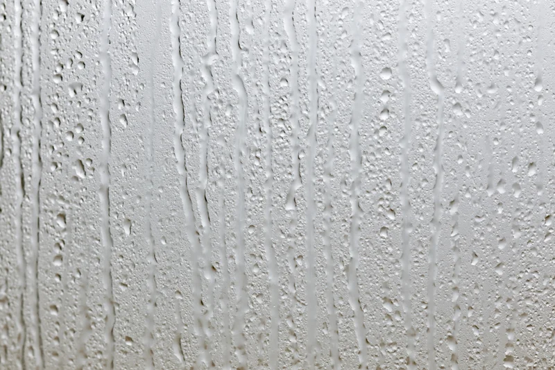 Close-up of water droplets and streaks on a wet glass surface