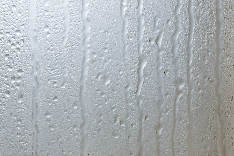 Close-up of water droplets and streaks on a wet glass surface