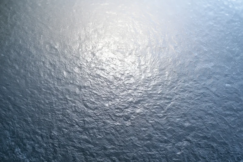 Close-up of frosted glass surface with icy texture and light reflection
