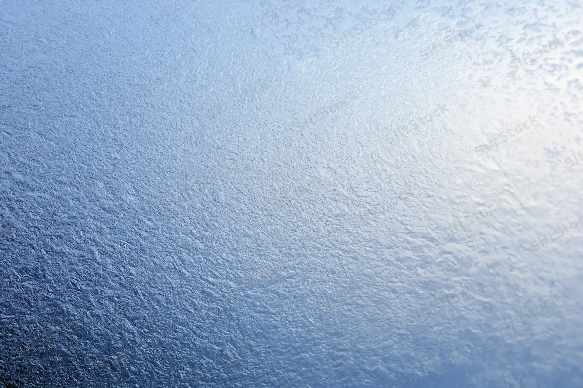 Close-up of frosted glass surface with icy texture and light gradient