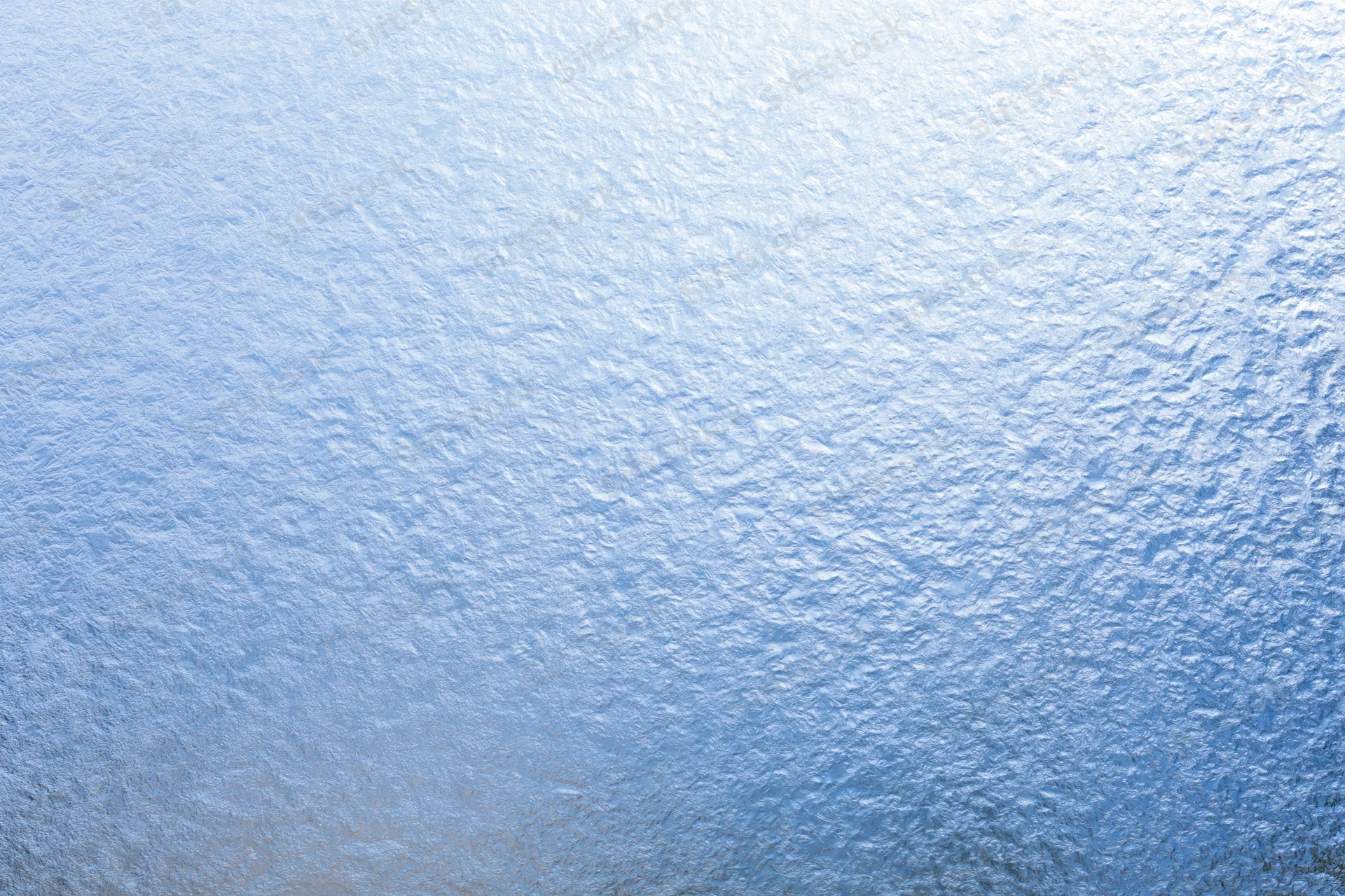 Close-up of frosted glass surface with icy texture and blue light gradient