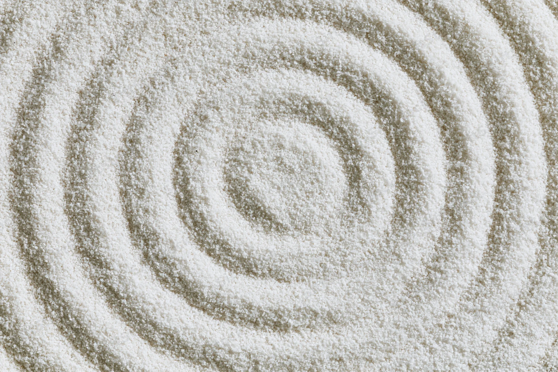 Concentric circles raked into fine white sand in a zen garden