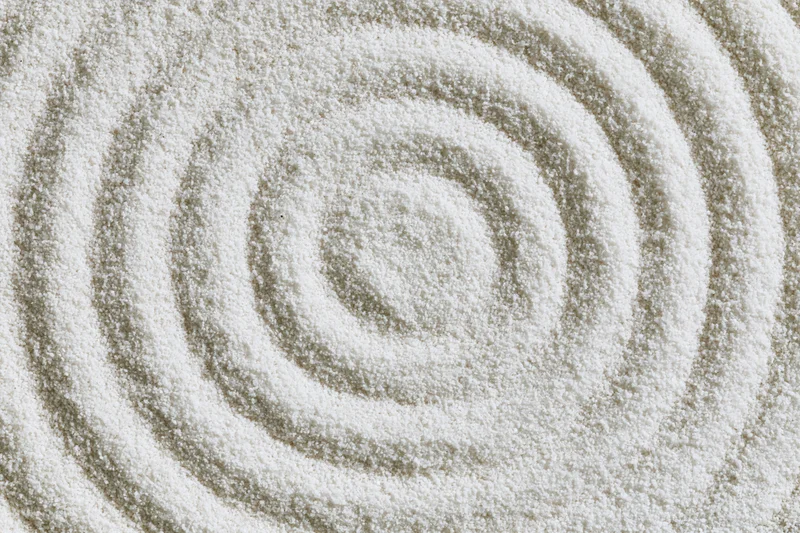 Concentric circles raked into fine white sand in a zen garden