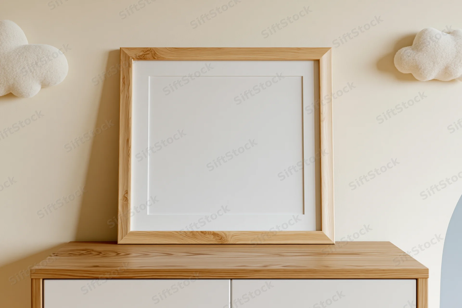 Empty light wood picture frame with white mat leaning against a cabinet in a nursery