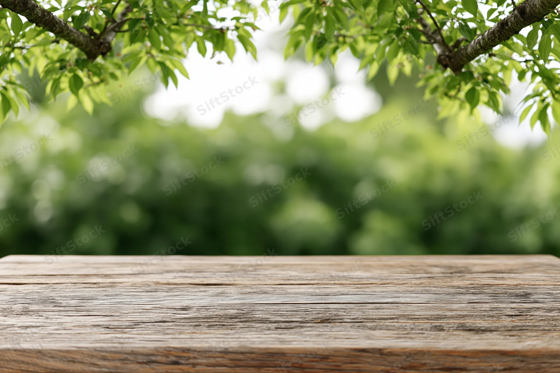 Weathered wooden tabletop in a lush green garden setting