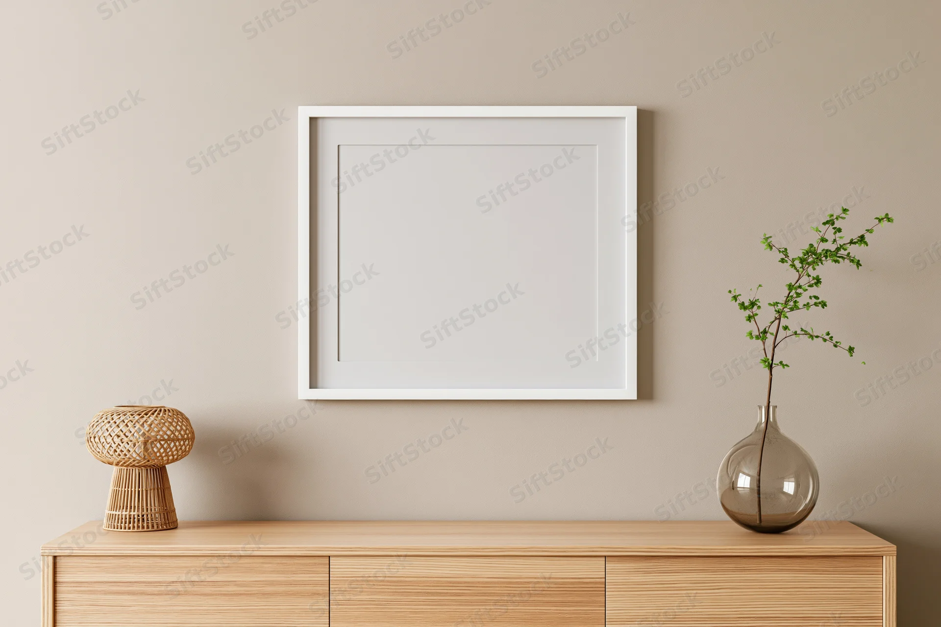 Empty white square frame hanging on warm greige wall above wooden cabinet with vase and woven basket