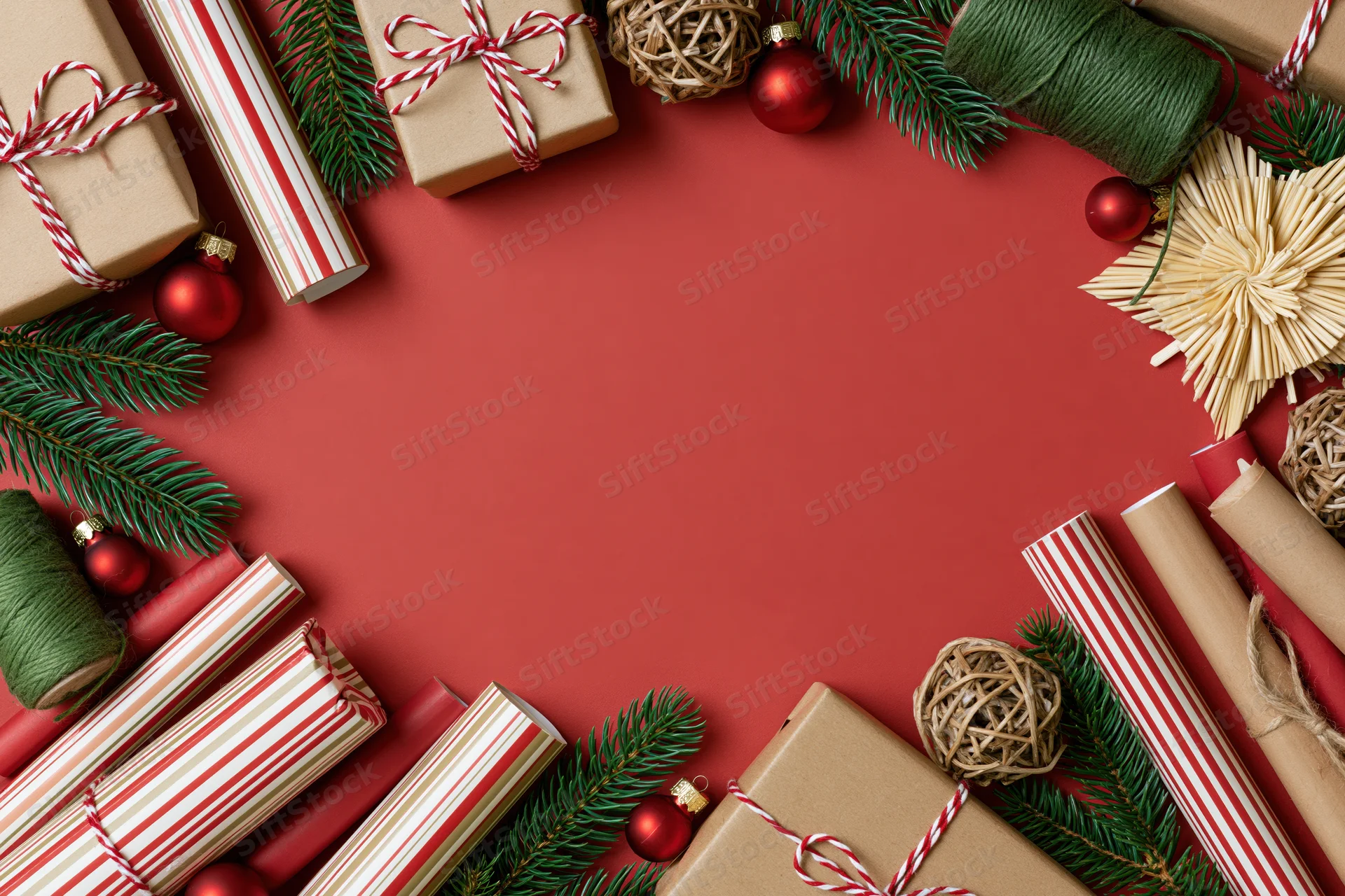 Christmas gift wrapping supplies arranged in a flat lay on red background with copyspace