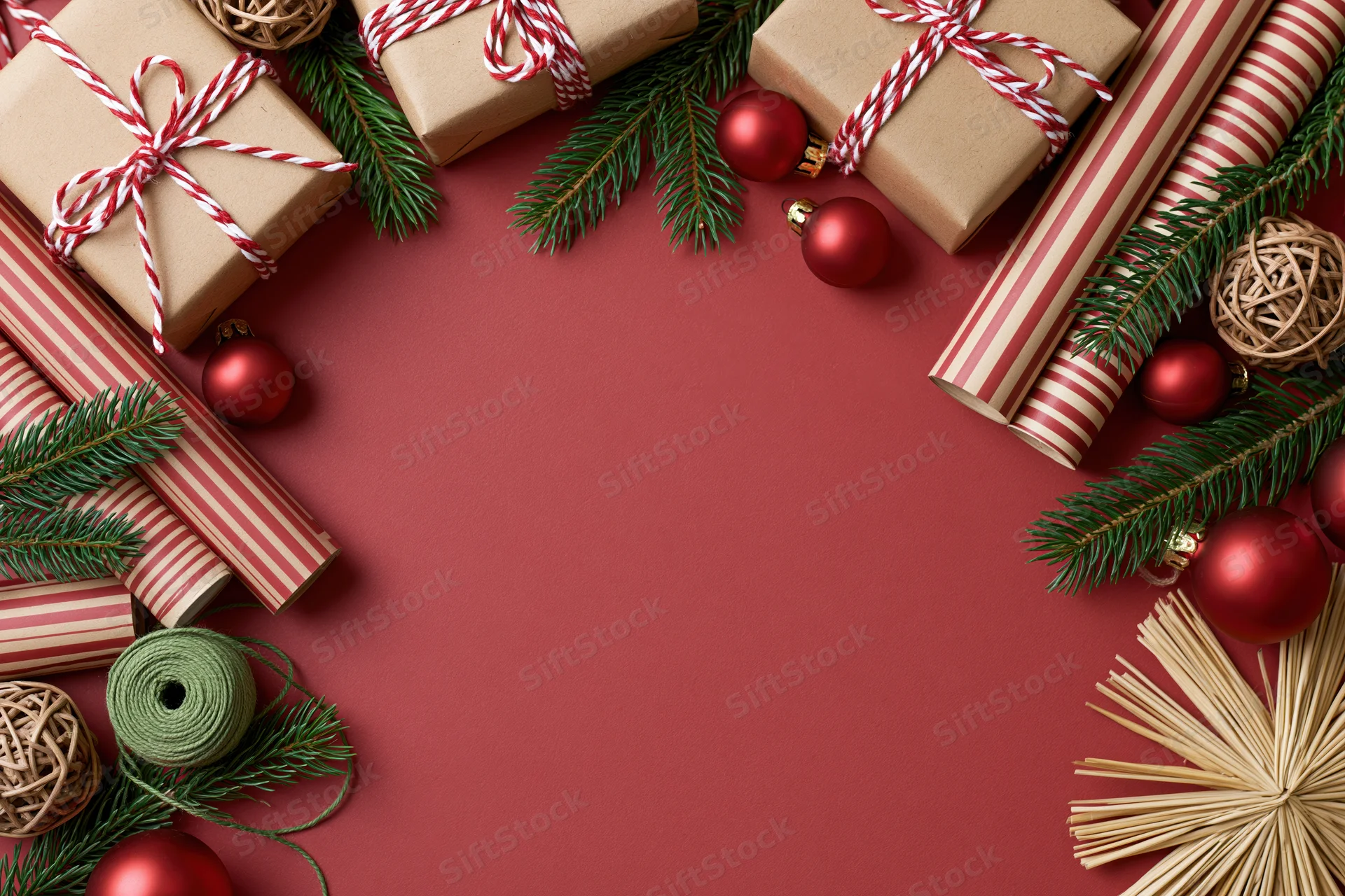 Christmas gift wrapping supplies arranged in a flat lay on red background with copyspace