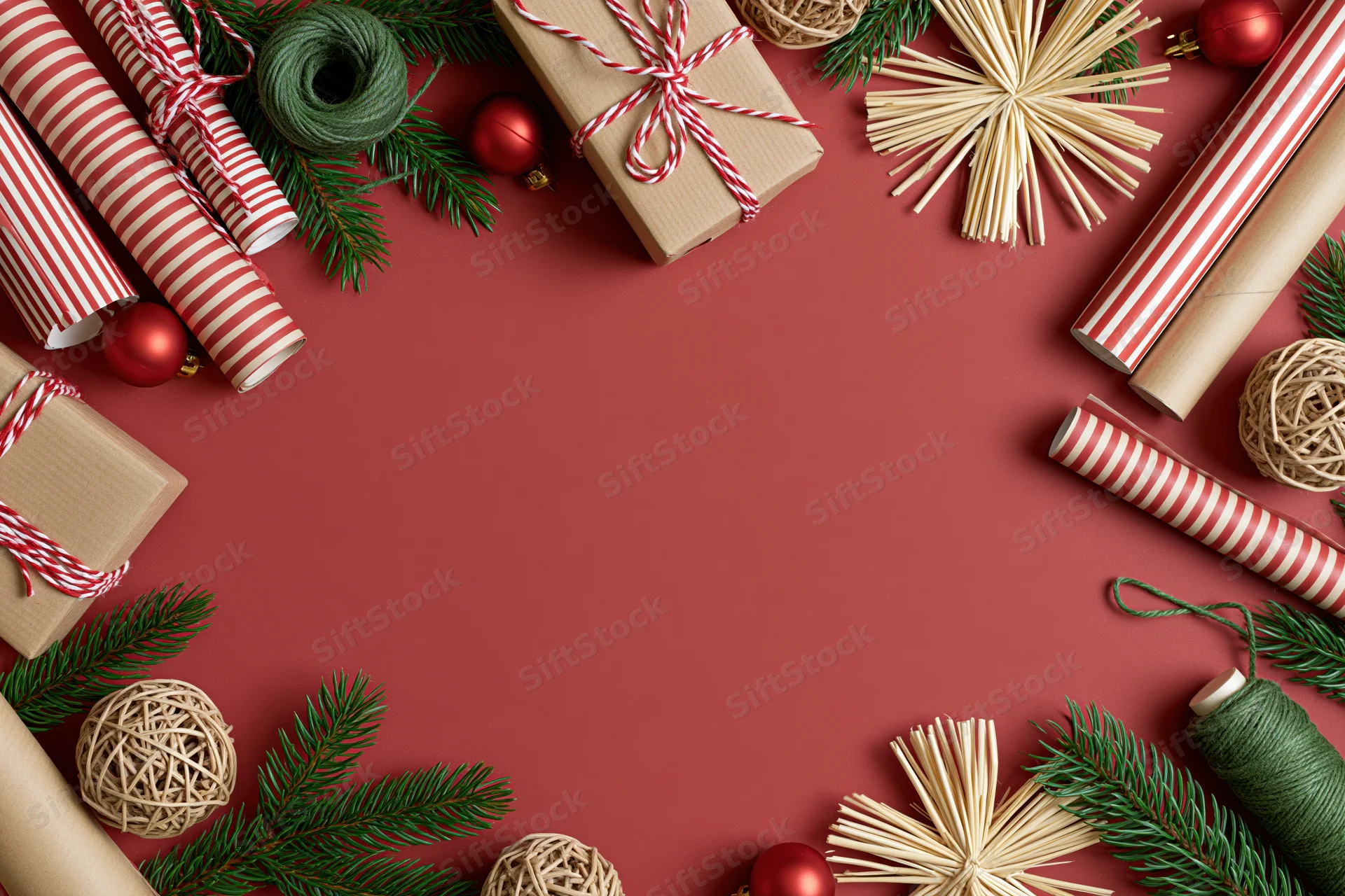 Christmas gift wrapping supplies arranged in a flat lay on red background with copyspace
