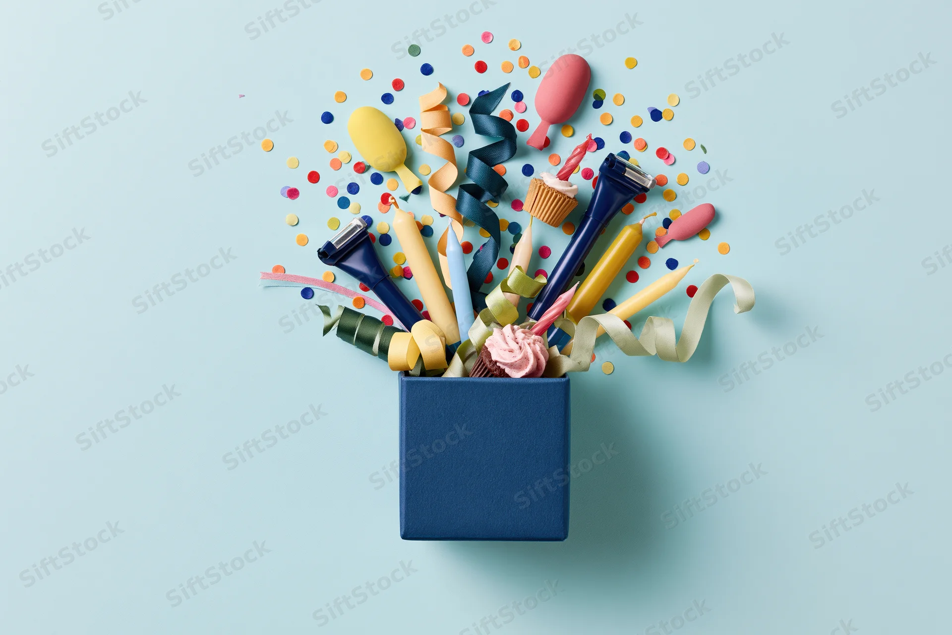 Dark blue gift box filled with birthday party items and grooming products on a light blue background