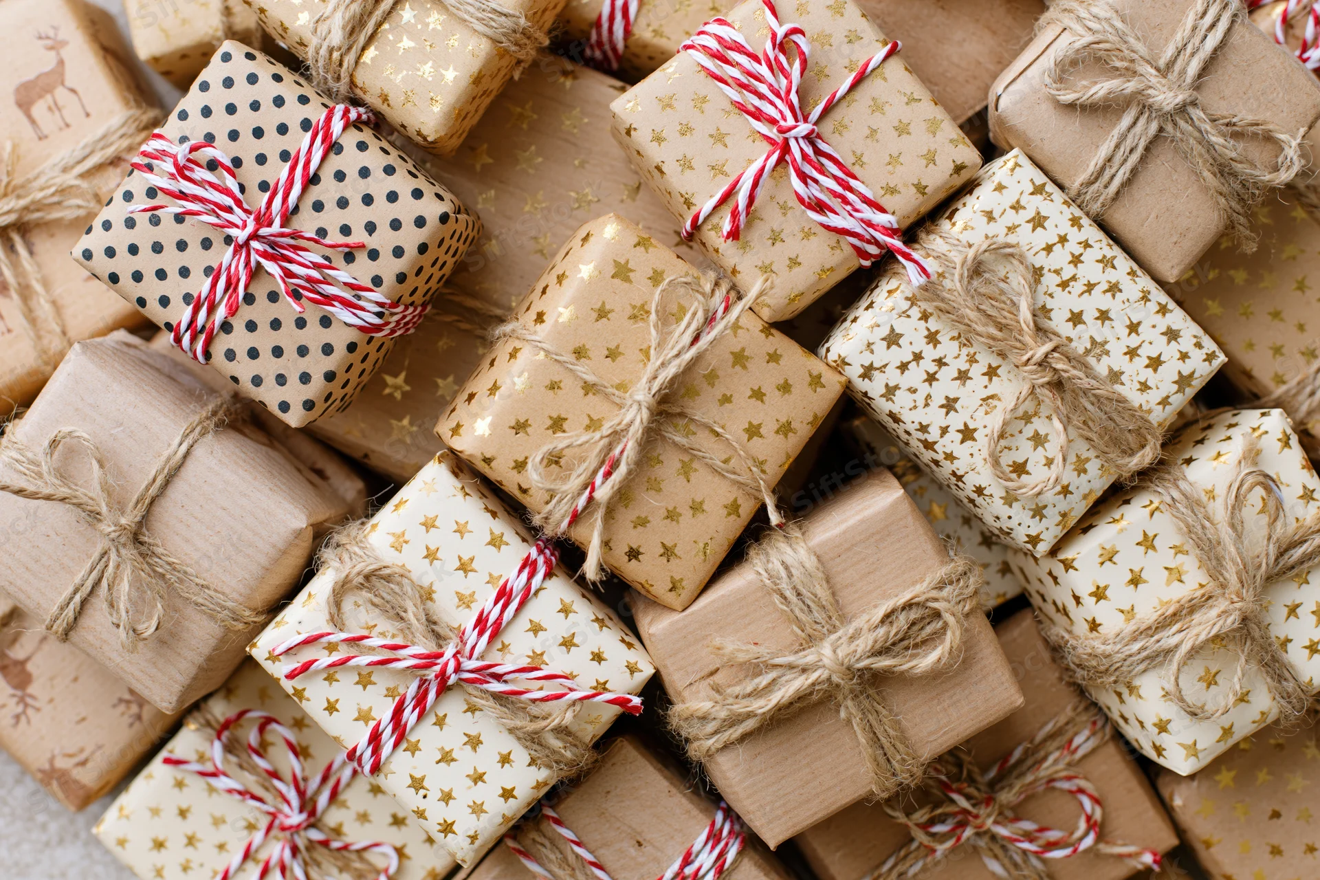 Many wrapped gift boxes arranged tightly in a flat lay overhead view