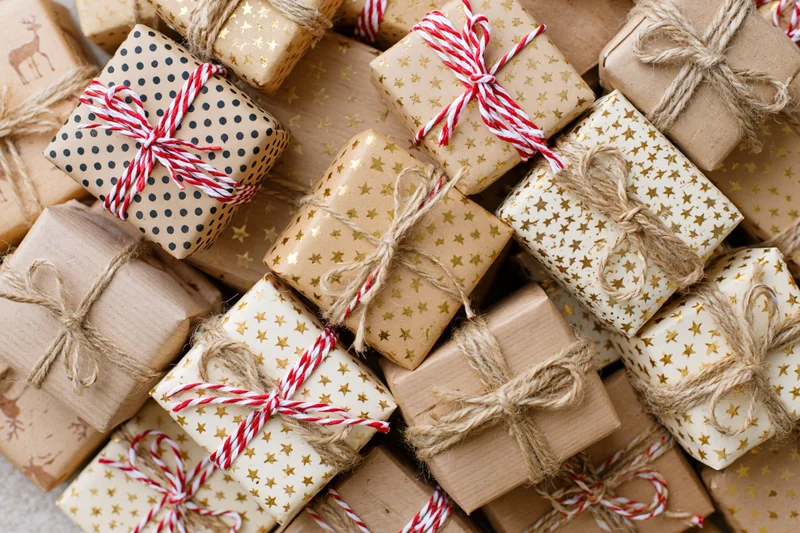 Many wrapped gift boxes arranged tightly in a flat lay overhead view