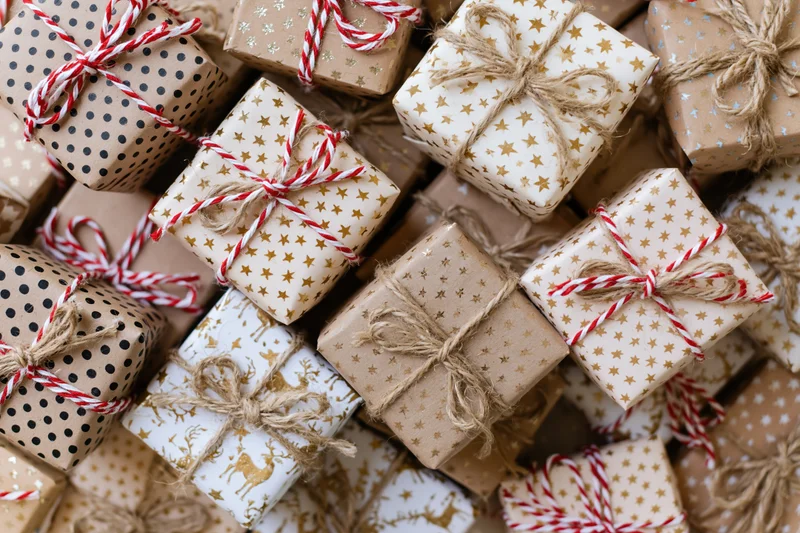 Many wrapped gift boxes packed tightly together in a flat lay arrangement