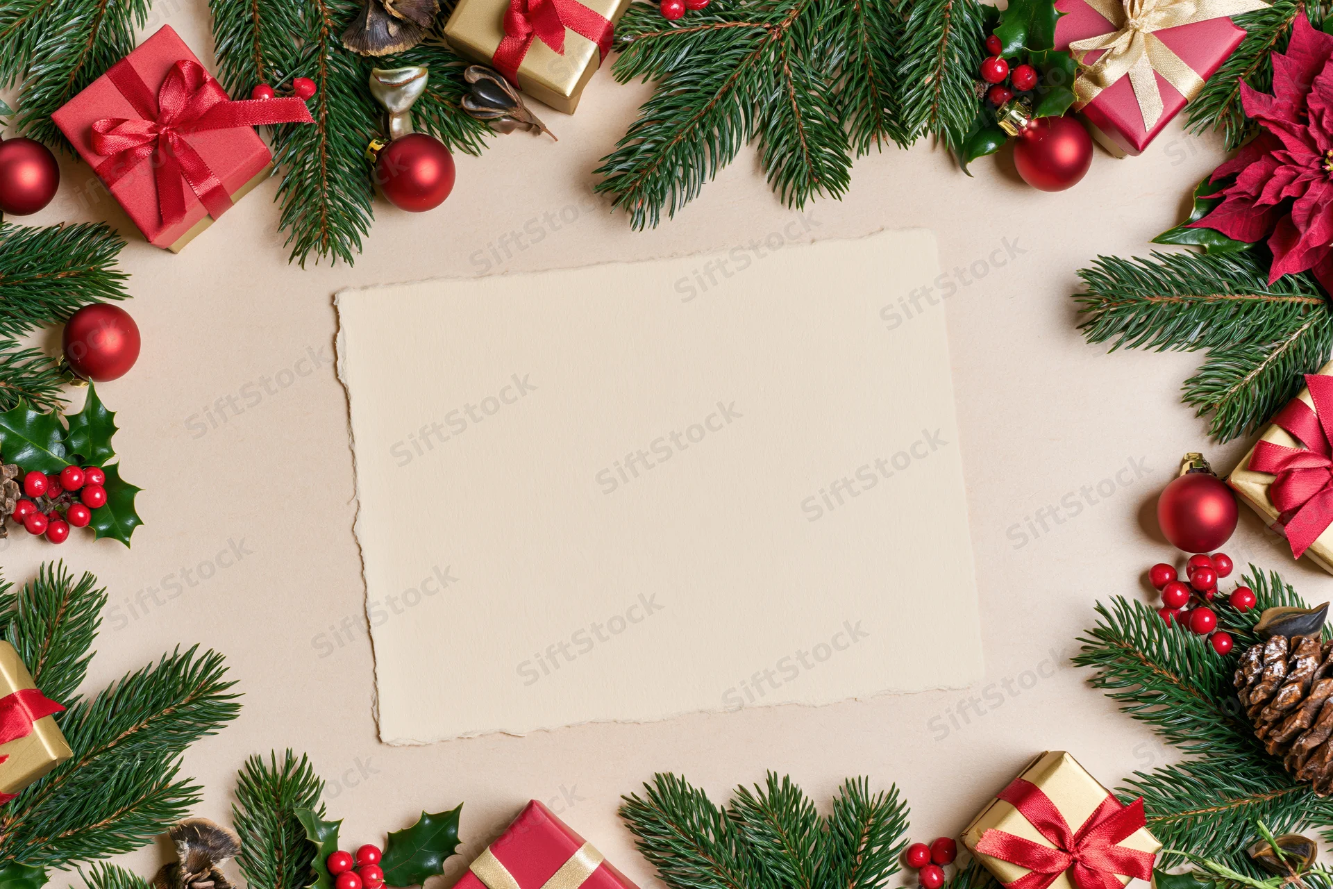 Christmas decorative border framing blank paper card with gifts and foliage overhead flat lay
