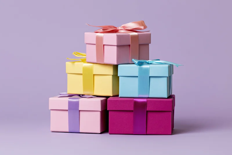 Stack of pastel gift boxes with ribbons arranged in pyramid on lavender background