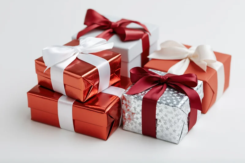 Wrapped gift boxes stacked and grouped on a white surface