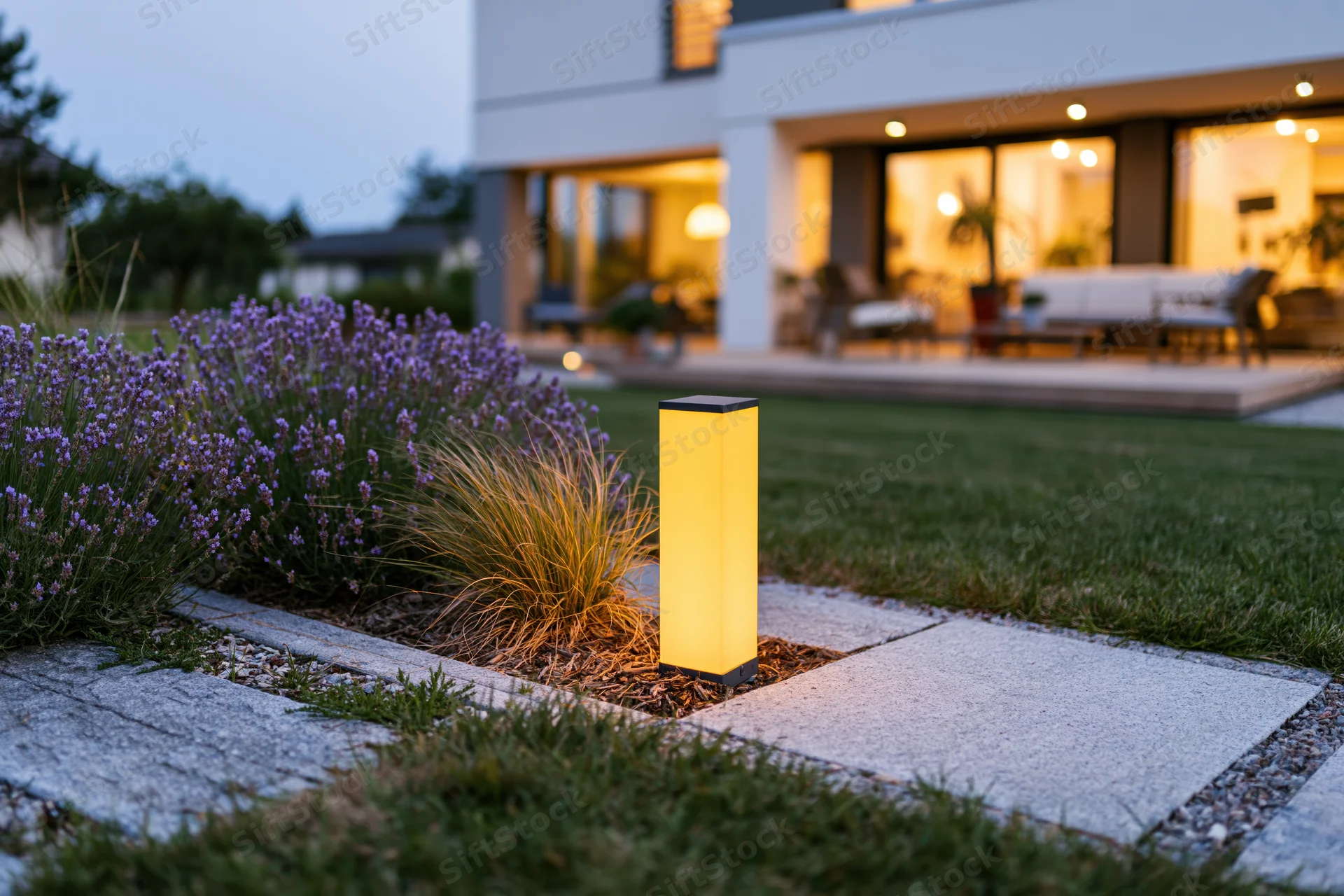 Modern suburban backyard with low bollard light illuminating stone pathway at dusk