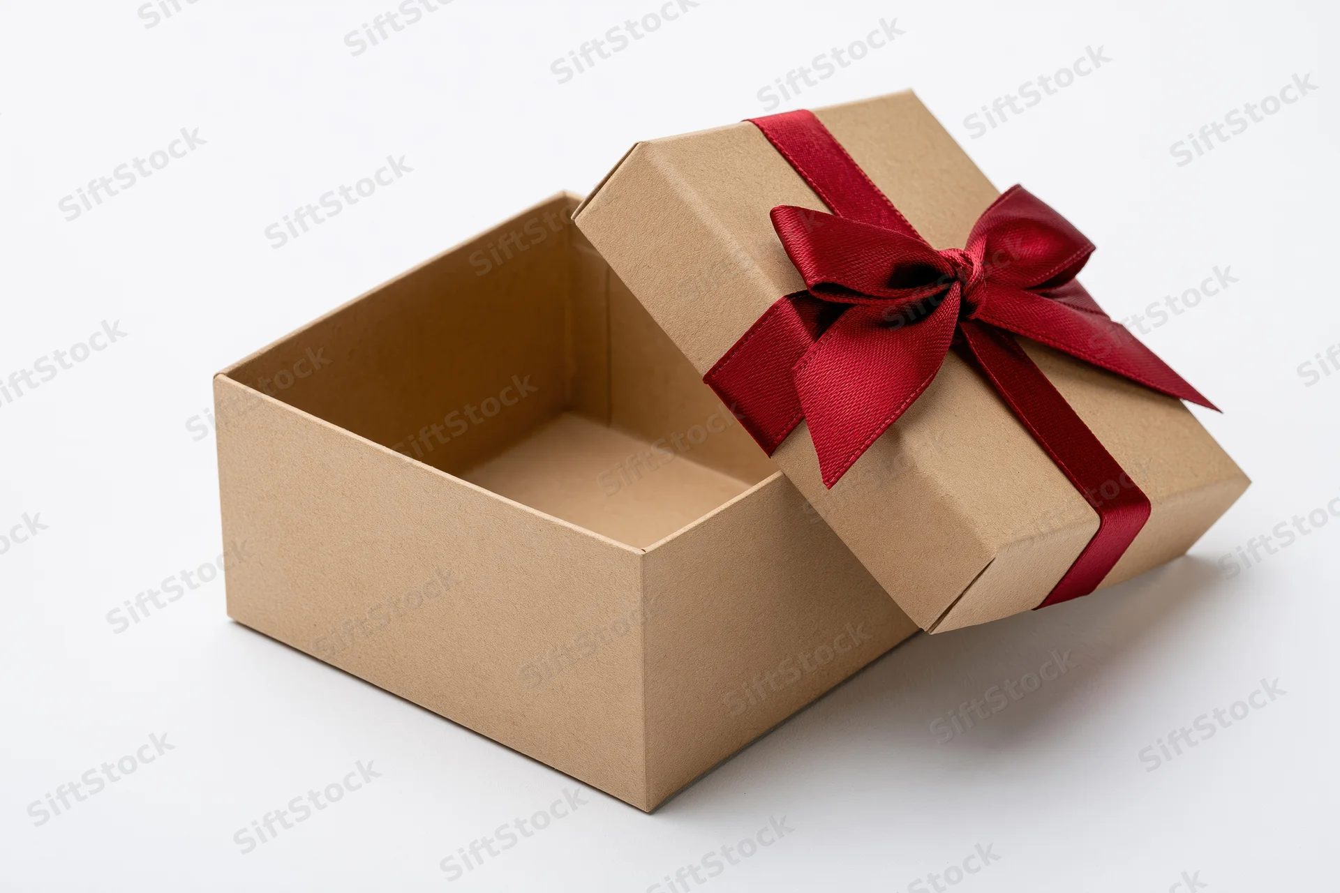 Open kraft cardboard gift box with red ribbon bow on white background