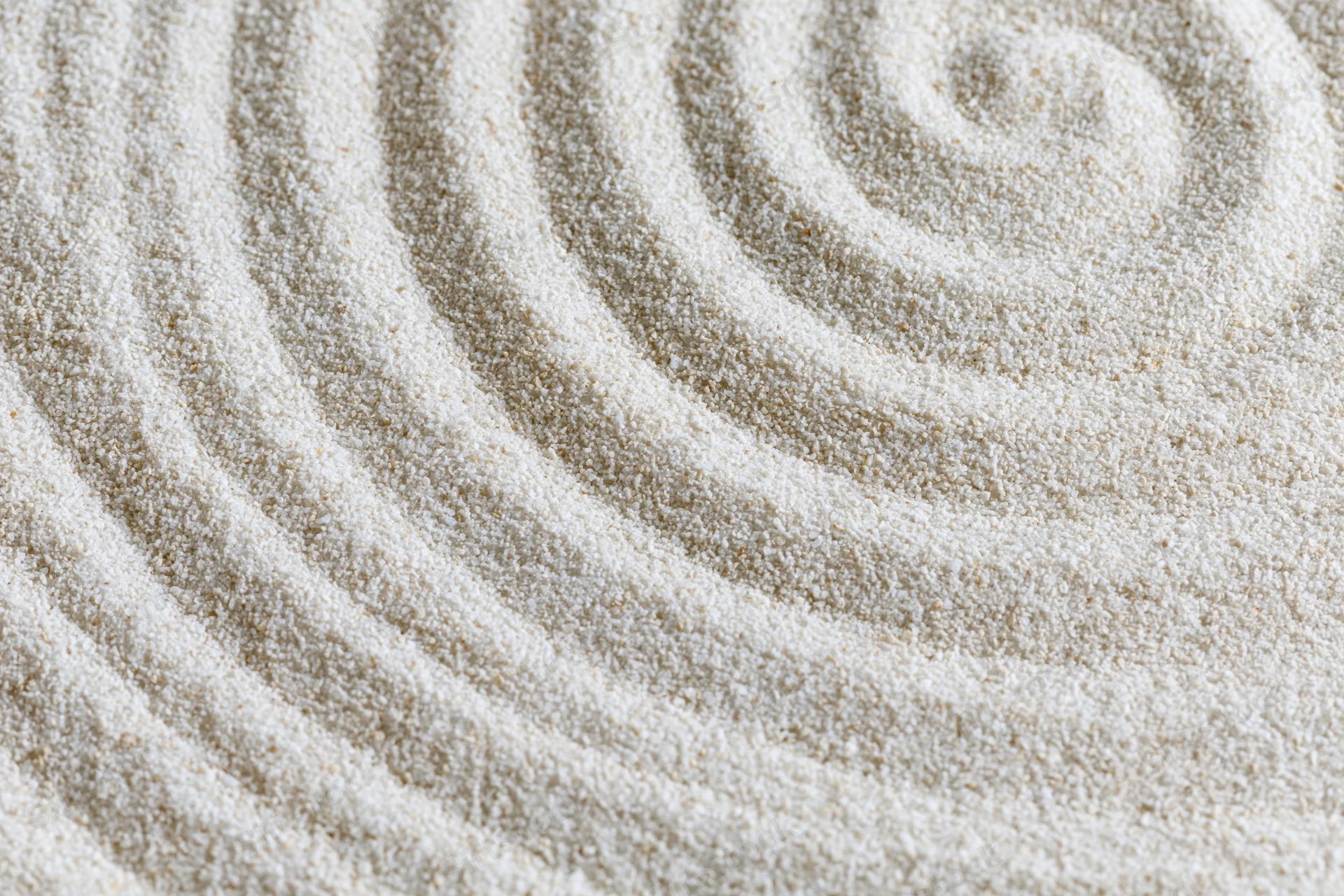 Raked sand surface with spiral pattern in a zen garden