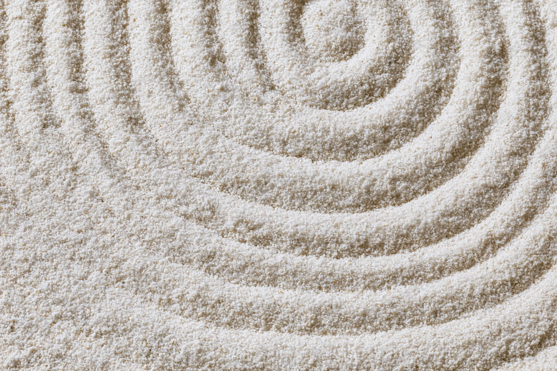 Raked sand surface with spiral pattern in a zen garden