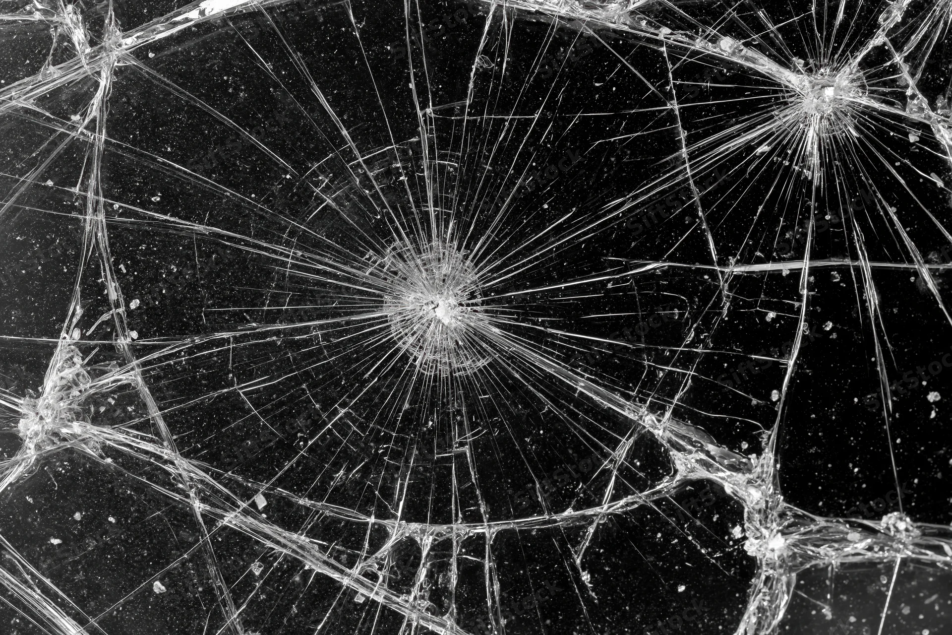 Shattered glass pane with radiating cracks across the entire frame