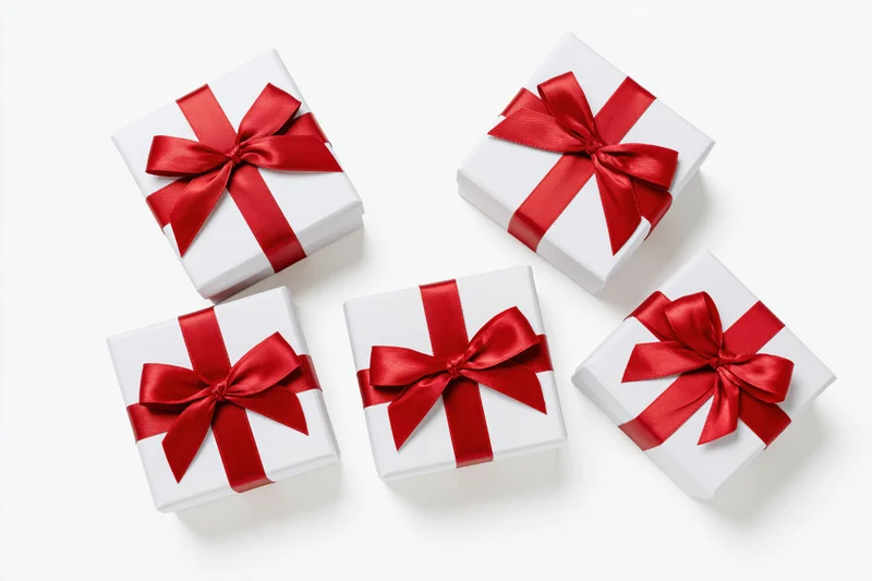 Five white gift boxes with red satin bows arranged on a white surface